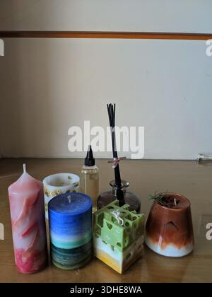 Eine Sammlung dekorativer Kerzen und Schilfdiffusoren auf einer Holzoberfläche Stockfoto
