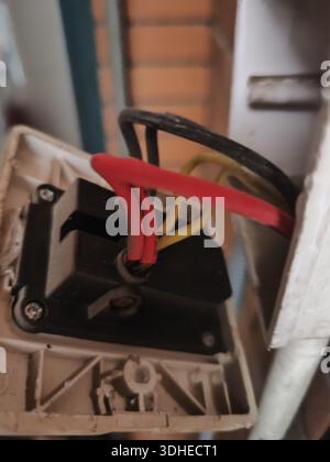 Elektrische Verkabelung in einem Schaltkasten mit roten, schwarzen und gelben Kabeln Stockfoto