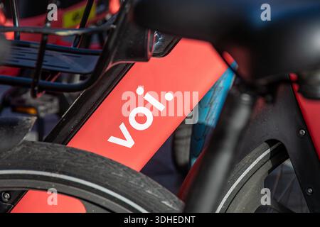 VOI-Markenlogo auf einem docklosen Mietrad. VOI Technology ab ist ein schwedischer Anbieter von Elektrorollern und Gemeinschaftsfahrrädern Stockfoto