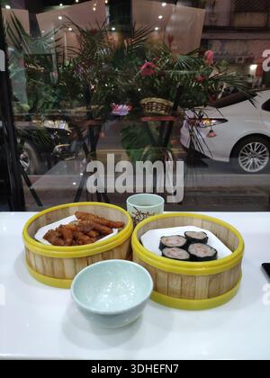 Dampfender Dim Sum in Bambuskörben auf einem Restauranttisch Stockfoto