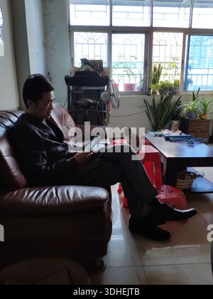 Mann, der sich auf der Couch mit Katze in der Nähe im Wohnzimmer entspannt Stockfoto