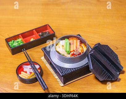 Japanisches Kameshi-Reisgericht, gekocht in einem eisernen kama-Topf mit Ikura-rotem Kaviar, Edamam-Sojabohnen in der Kapsel, gegrilltem Unagi-Aal, Wachtelei, Bambusschießen Stockfoto