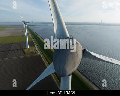 Windenergie, die auf landwirtschaftlichen Flächen Strom auf dem Wasser erzeugt Stockfoto