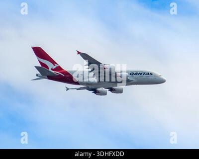 QANTAS A380 fliegt durch blauen und bewölkten Himmel. Stockfoto