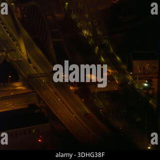 Nächtliche Luftaufnahme der städtischen Überführung und Brücke mit beleuchteten Straßen und spärlichem Verkehr. Ruhige Stadtinfrastruktur von oben. Aufgenommen mit der Sony A7 IV. Hallo Stockfoto