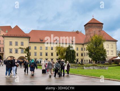 Touristen, die am 11. Oktober 2025 im Hof des Königsschlosses Wawel in Krakau, Polen, spazieren gehen. Historische Renaissance-Schlossanlage mit rotem Fliesenzimmer Stockfoto