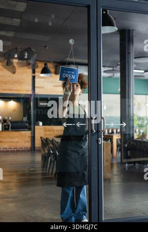 Blau „Ja! Das Schild „WIR ÖFFNEN“ hängt in der Doppeltür des Cafés, Reflexionen Stockfoto