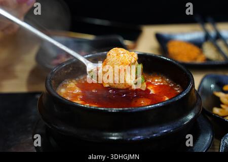 Löffel scharfer koreanischer, weicher Tofu-Eintopf (Sundubu Jjigae) Stockfoto
