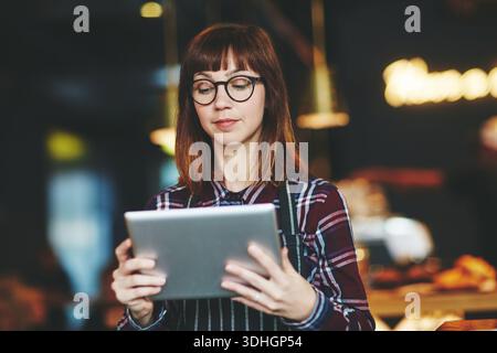 Tablet, Gastfreundschaft und Frau im Restaurant, Online-Checkliste und digitale App für Menüoptionen. Unternehmer, Geschäftsinhaber und Person im Café, Techniker Stockfoto