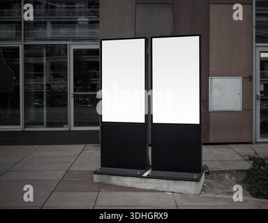 Zwei leere weiße vertikale Leuchtkästen in einer Stadt. Mock up der Plakate. Stockfoto