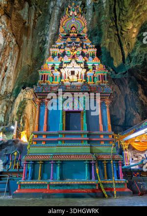 Lebendiger Sri Subramaniar Swamy Tempel in Batu Caves, Gombak, Selangor, Malaysia. Verzierte hinduistische Architektur mit bunten Gottheiten und komplizierten Details in einer natürlichen Kalksteinhöhle Stockfoto