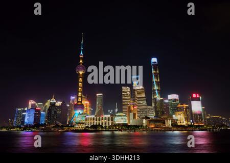 Langzeitbelichtung des Stadtteils Shanghai Pudong vom Bund bei Nacht mit Lichtern, die im Huangpu-Fluss reflektiert werden Stockfoto