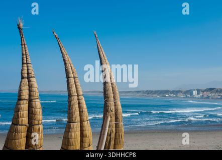 Huanchaco Nr Trujillo Peru „Caballitos de totora“ stehen am Pazifik-Strand. Caballitos de totora ist ein traditionelles Schilfhandwerk Stockfoto