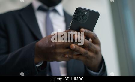 Verärgert afroamerikanischer männlicher Geschäftsmann Geschäftsmann im Büro, der Smartphone liest schlechte Nachrichten besorgt mit Handy frustriert gestresst Stockfoto