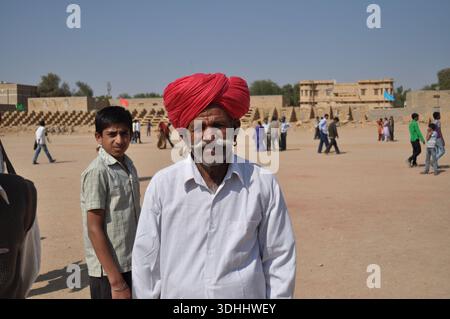 Ein älterer Mann mit rotem Turban steht auf dem offenen Platz in Jaisalmer, Rajasthan, Indien Stockfoto