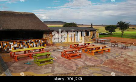 Genießen Sie Mahlzeiten im Freien im hellen Innenhof mit farbenfrohen Wandgemälden und rustikaler Atmosphäre Stockfoto