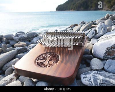 Kalimba-Musikinstrument auf Steinen auf dem Seeweg. Natur in der Nähe von Bergen, Musik und Meditation. Entspannung und psychische Gesundheit. Stockfoto
