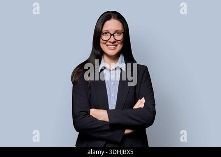 Selbstbewusste erfolgreiche Geschäftsfrau mittleren Alters in schwarzer Jacke auf hellem Studiohintergrund Stockfoto