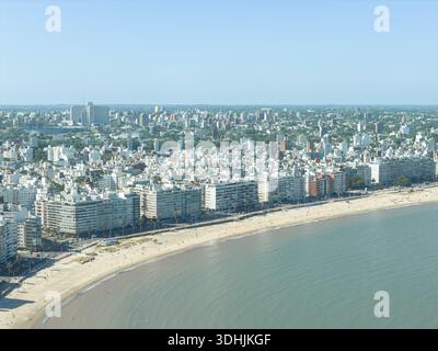 Aus der Vogelperspektive auf die Küste, wo die Stadt auf das Meer trifft, eine Mischung aus urbanen Strukturen und Sandstränden entlang des Wassers, Montevideo, Departam Stockfoto