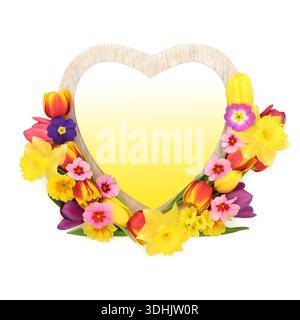 Frühlingsjahresblüte Arrangement mit Herzkranz auf weißem Hintergrund mit gelber Farbverlaufsfüllung. Romantisches Design für Frühling und Ostern. Stockfoto