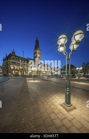 Hamburger Rathaus mit beleuchteter blauer Stundenfassade und Straßenlaterne im Vordergrund, Hamburg, Deutschland Stockfoto