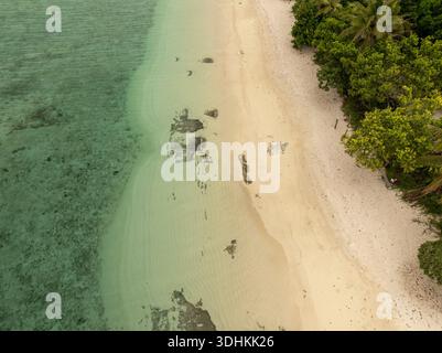 Aus der Vogelperspektive auf die Küste, wo türkisfarbenes Wasser auf unberührten Sand und üppiges Grün trifft, Mystery Island, Vanuatu. Stockfoto