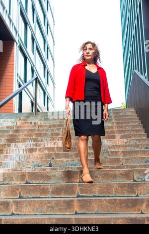 Professionelle Frau, die Treppen in städtischer Umgebung absteigt Stockfoto