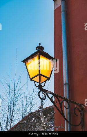 Beleuchtete Straßenlaterne hängt an der Fassadenwand in der Altstadt von Varazdin, Kroatien Stockfoto