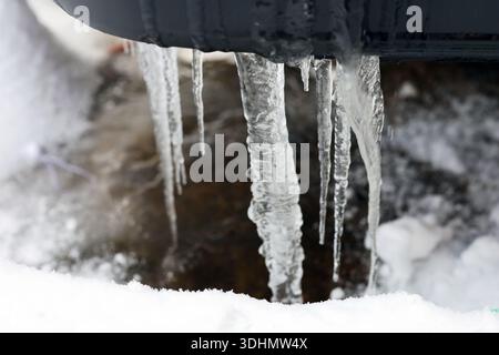 Heck eines Fahrzeugs, das bei eisigen Winterverhältnissen mit Schnee und Eiszapfen bedeckt ist. Eisansammlungen auf dem Außenbereich des Fahrzeugs heben extreme Kälte hervor. Stockfoto