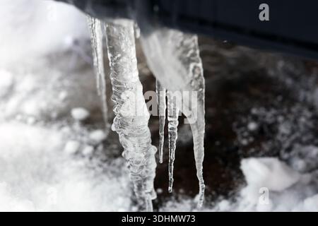 Heck eines Fahrzeugs, das bei eisigen Winterverhältnissen mit Schnee und Eiszapfen bedeckt ist. Eisansammlungen auf dem Außenbereich des Fahrzeugs heben extreme Kälte hervor. Stockfoto