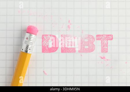 Löschen von Wort Schulden in Notizbuch auf Tabelle, Draufsicht Stockfoto