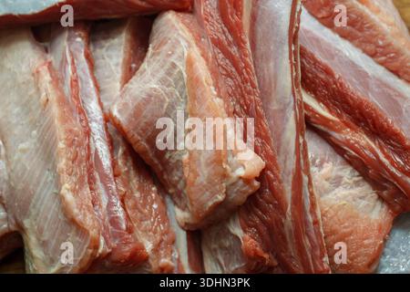 Schließen Sie die Textur roher Schweinerippchen mit Fleisch und Knochen. Frische Zutaten zum Grillen oder Rösten. Stockfoto