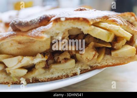 Die Konsistenz der Apfelkuchenscheibe zeigt saftige Füllung und weichen Teig. Gebackenes süßes Dessert. Stockfoto