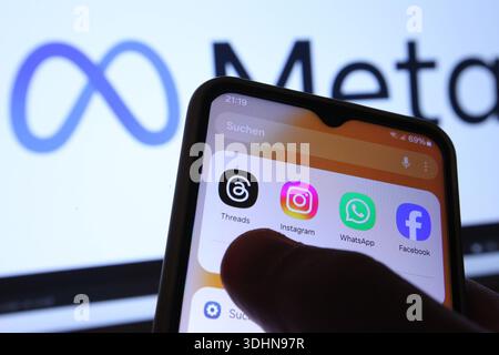 Auf einem Smartphone sind die Apps von Threads, Instagram, WhatsApp und Facebook zu sehen. Dahinter wurde auf einem Laptop das Logo des Betreibers Meta Platforms aufgerufen. Symbolbild/Symbolfoto. Schnelsen Hamburg *** die Apps von Threads, Instagram, WhatsApp und Facebook sind auf einem Smartphone dahinter zu sehen, das Logo des Betreibers Meta Platforms wurde auf einem Laptop aufgerufen Symbol Bild Symbol Foto Schnelsen Hamburg Stockfoto