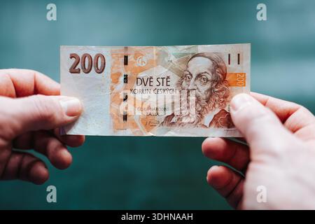 Nahaufnahme der Hände, die tschechische Kronen-Banknoten halten. Konzept der geringen Barmittelmenge, Budgetierung und persönlicher Finanzkontrolle. Realistische Sicht auf die physische Stockfoto