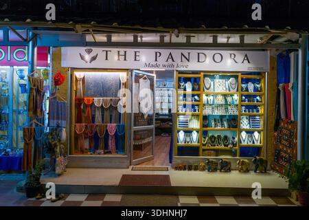 Varkala, Indien - 2. März 2023: Das Bild zeigt die beleuchtete Ladenfront des Pandora-Ladens bei Nacht mit Schmuck, Halsketten und Pashmina-Tüchern mit dekorativen Elefantenfiguren davor. Stockfoto