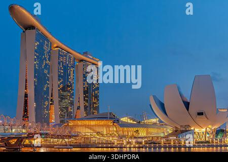 Nächtlicher Blick auf das Marina Bay Sands Hotel und das Science Museum, beleuchtet über der Marina Bay in Singapur, mit Lichtern, die auf dem Wasser reflektiert werden Stockfoto