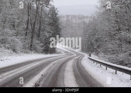 Schneebedeckte Kurve durch ein Tal in Frankreich Stockfoto