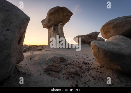 Blick auf die surreale Badlands-Landschaft mit pilzförmigen Felsformationen, die sich vor dem schwindenden Sonnenuntergang abzeichnen, Farmington, New Mexico, Unite Stockfoto