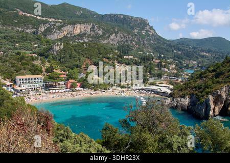 Ein atemberaubender Blick auf die berühmte Bucht von Paleokastritsa mit kristallklarem türkisfarbenem Wasser, einem Sandstrand und üppigen grünen Bergen. Stockfoto