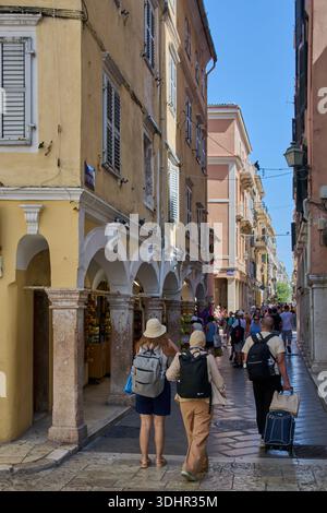 Korfu. Griechenland - 22. Januar 2026: Touristen erkunden die charmante Nikiforou Theotoki Straße in Korfu mit venezianischen Bögen, gelben Fassaden und Loc Stockfoto