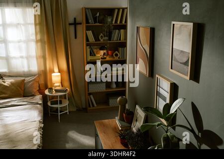 Modernes Schlafzimmer mit Bücherregal und gerahmter abstrakter Wandkunst Stockfoto