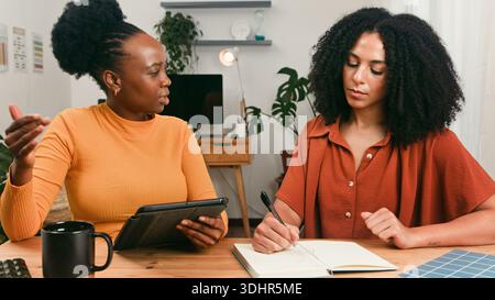 Teammeeting Zwischen Zwei Frauen Am Schreibtisch Mit Notebook Und Tablet Stockfoto