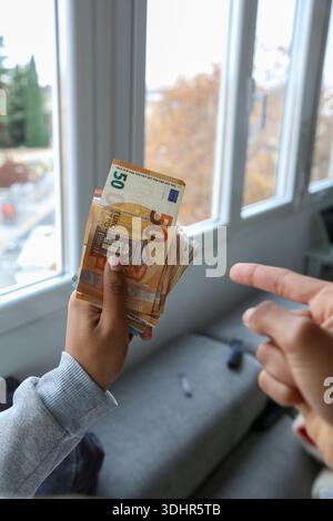 Ein Stück 50-Euro-Scheine, die von einer afroamerikanischen Frau gehalten werden Stockfoto
