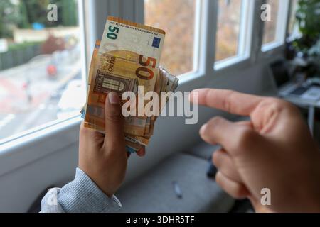 Ein Stück 50-Euro-Scheine, die von einer afroamerikanischen Frau gehalten werden Stockfoto