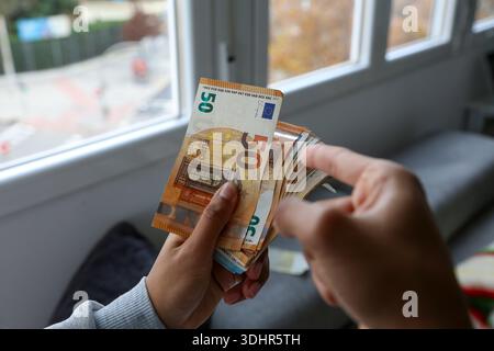 Ein Stück 50-Euro-Scheine, die von einer afroamerikanischen Frau gehalten werden Stockfoto
