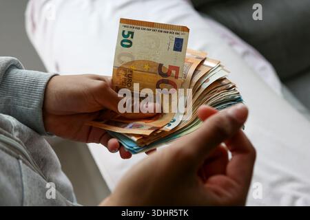 Ein Stück 50-Euro-Scheine, die von einer afroamerikanischen Frau gehalten werden Stockfoto