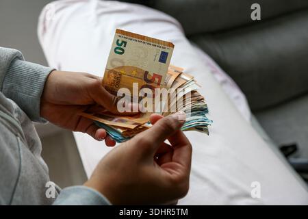 Ein Stück 50-Euro-Scheine, die von einer afroamerikanischen Frau gehalten werden Stockfoto