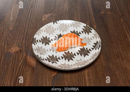 Verschiedene Sushi-Platte mit frischem Lachs in verschiedenen Zubereitungen, wie Nigiri und Brötchen, begleitet von einer Portion Stockfoto