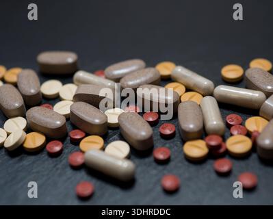 Verschiedene Pillen, Tabletten und Kapseln auf dunklem Hintergrund, pharmazeutisches Konzept Stockfoto